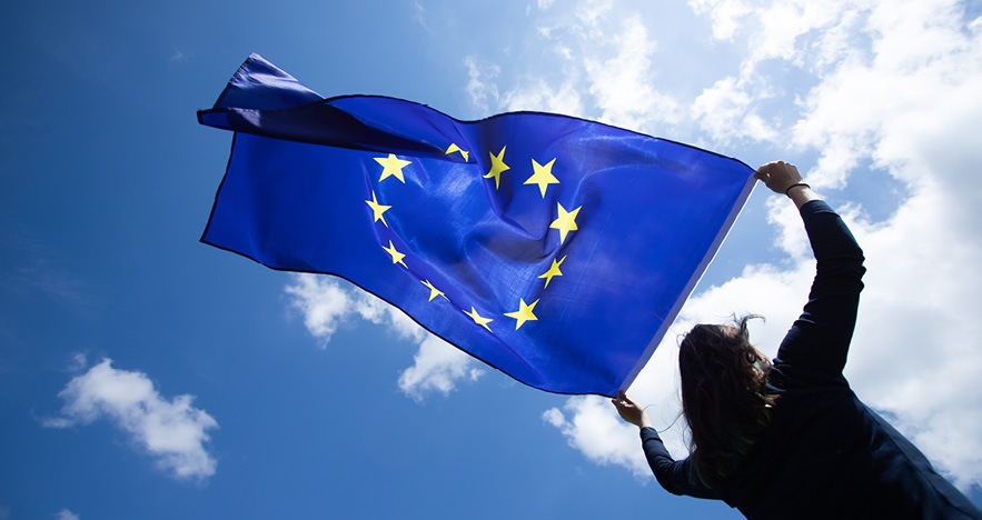 Blog Thumbnail - Reopening European Countries Woman holding a EU flag