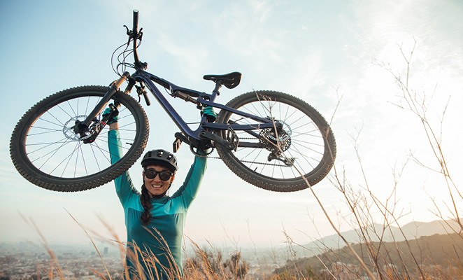 woman holding bicycle in mountains near barcelona