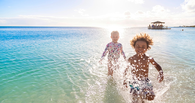 family vacation with kids running on the beach